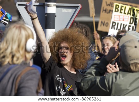 THE HAGUE - OCTOBER 15: An unidentified young man raises his anonymous mask and shouts at the police during the Occupy protest on October 15, 2011 in The Hague, The Netherlands.