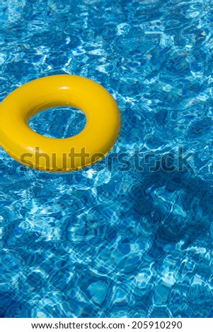 Yellow pool float, pool ring in cool blue refreshing swimming pool