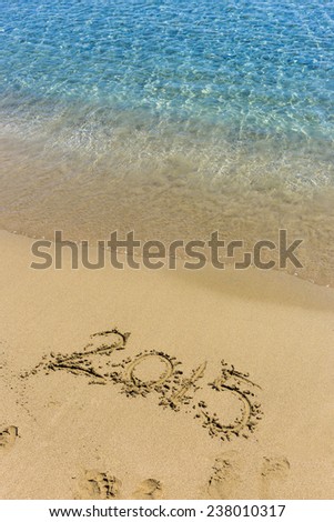 New year 2015 write on sand beach under blue sky and ocean view.