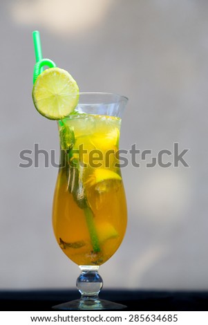 golden iced tea with green straw and mint