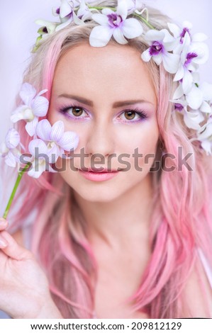 tender girl with pink hair in these orchids, close-up
