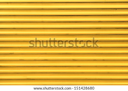 Yellow, steel, shiny rolling shutter door texture with horizontal lines.