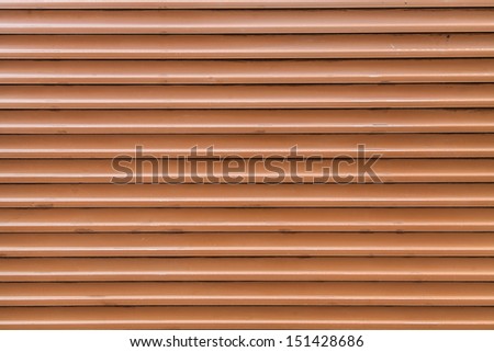 Dark orange rolling shutter door texture with horizontal lines.