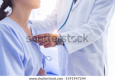 Doctor use stethoscope, checking up heart beat, lunch of auscultation in doctor office at hospital. Patient worker has to get medical checkup every year for her health or medical checkup cardiologist Stock fotó © 