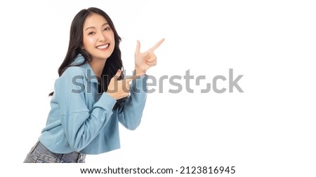 Photo of Beautiful young Asian woman pointing up to copy space and looking at camera with smile face and happy Pretty girl act like a satisfied product, use for advertising with isolated on white background