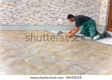 Floor tiles installation. Man installs ceramic tile