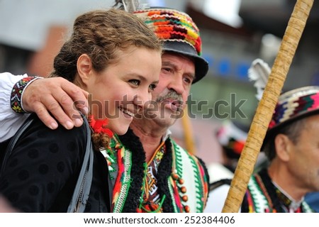 KIEV, UKRAINE - AUGUST 24: Laughing and happy young lady and a man nearby in national costumes at the All Ukrainian Vyshyvanka Parade on Maidan at Independence Day on August 24, 2013, Ukraine.