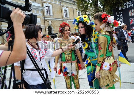 KIEV, UKRAINE - AUGUST 24: Ukrainian women with embroided bodyart instead of clothes giving an interview at Independence Day on August 24, 2013 in Kiev, Ukraine