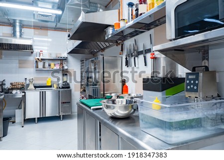 Kitchen of a working restaurant without people. No one is inside cafe kitchen. Concept - work in restaurant kitchen. Work as cook in a cafe. Career in horeca industry. Chromed equipment in cook room