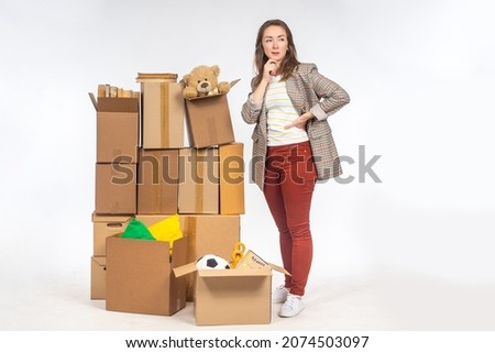 Old things in boxes. Concept - unnecessary personal items in woman's boxes. She thinks about storage space. Woman with boxes on light background. She needs place for personal storage ストックフォト © 