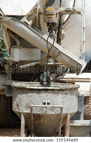 Cranes and buckets of cement for the construction of a building.