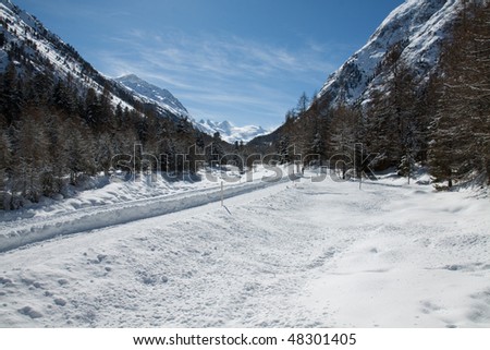 Winter Mountain Panorama on Alps full of snow and ice. Road inside the snow