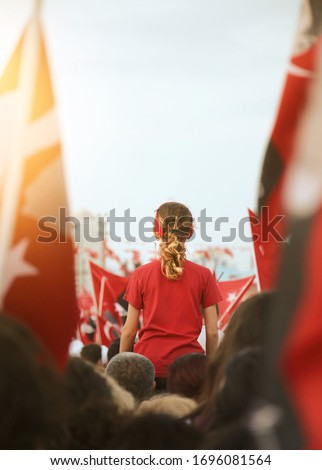 Izmir, Turkey - October 29: A girl between Turkish Flags at Celebrations of Republic day of Turkey. April 23: National sovereignty and children's day concept.