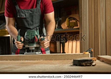 Similar – Image, Stock Photo Skilled woodworker using milling machine while working with lumber in contemporary workroom