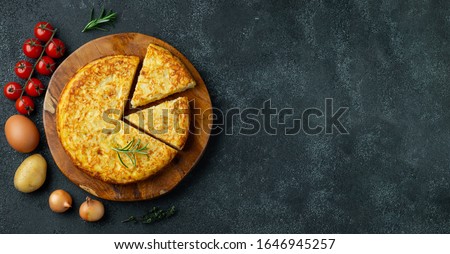 Spanish omelette with potatoes and onion, typical Spanish cuisine on a black concrete background. Tortilla espanola. Top view with copy space Сток-фото © 