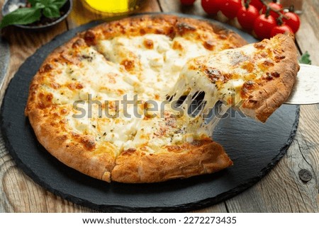 Similar – Foto Bild Pizza mit vier Käsesorten auf dem klassischen blauen Tisch. Pizzascheibe flachgelegt