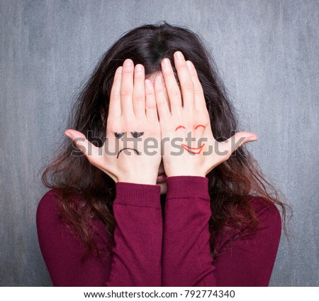 Different states of mood, woman covering her face with hands with drawn happy and sad  商業照片 © 