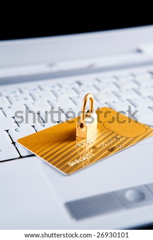 The golden lock in on top of the gold credit card on the laptop. All the important information from the card has been removed and modified. Focus mainly on front side of the lock.