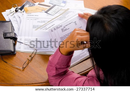 A woman looked so stress looking at credit card\'s bill all other debt invoice.