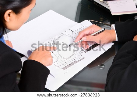 Two business people discuss about the property plan by showing the map.
