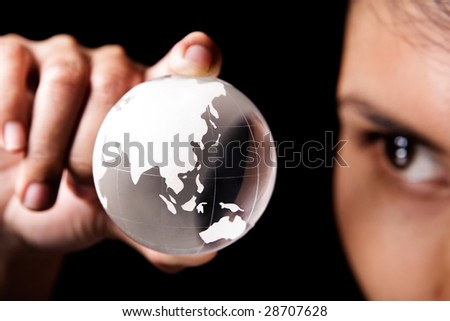 A woman examining a glass globe which showing Asia and Australia continent