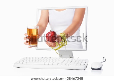 Female hand holding red apple coming out from computer screen isolated over white background