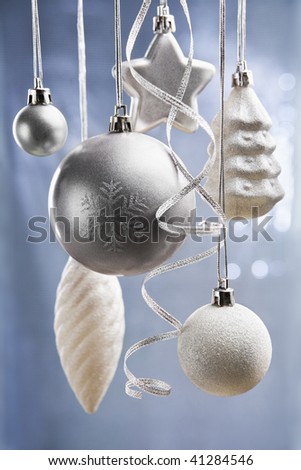 Silver and white Christmas ornaments over blue background