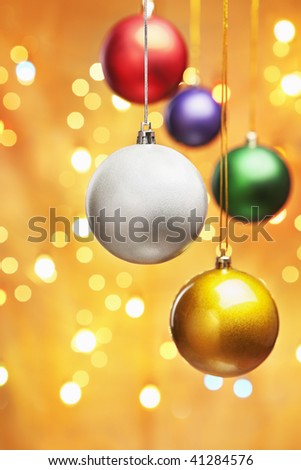 Colorful Christmas ornaments with golden background filled by blurred light