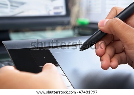Hand using digital pen tablet for working in office