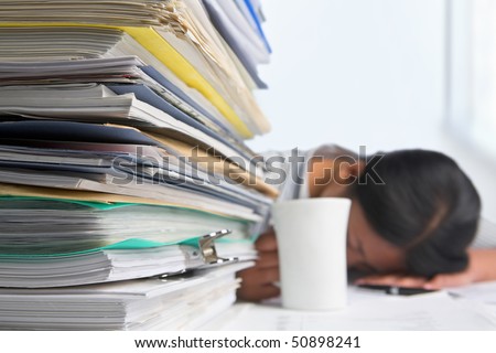 Heavy workload concept with pile of paper and woman on background. Selective focus