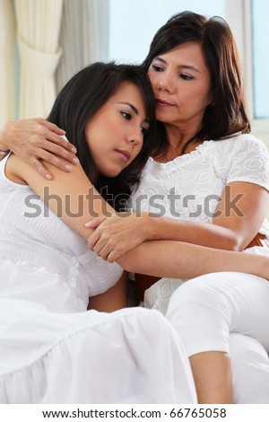 Mother consoling her sad daughter who has problem