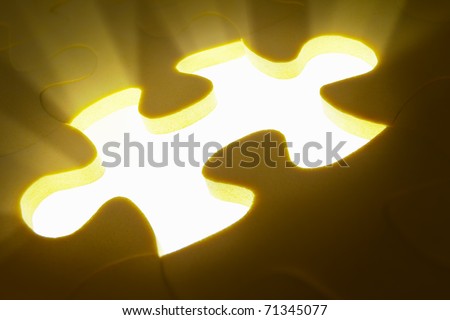 Concept photo using piece of puzzle with ray of light comes out from missing piece