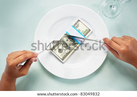 People hand eating the dollar bills on the plate