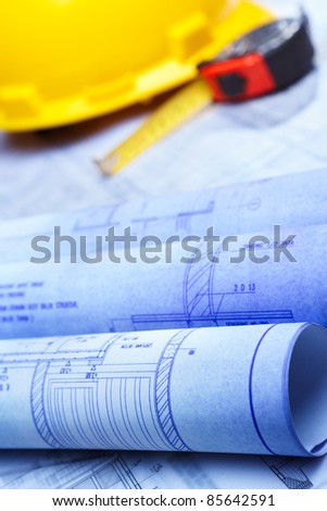 Architect design printout in bluish color with yellow safety helmet