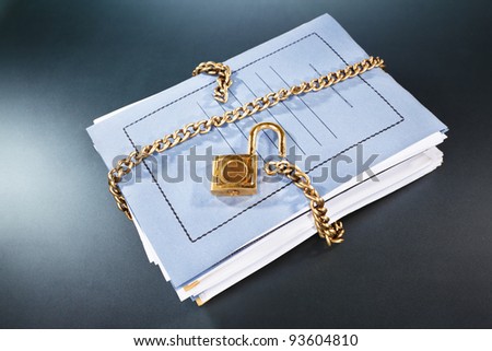 Stack of files and folder being surrounded by unlocked chain