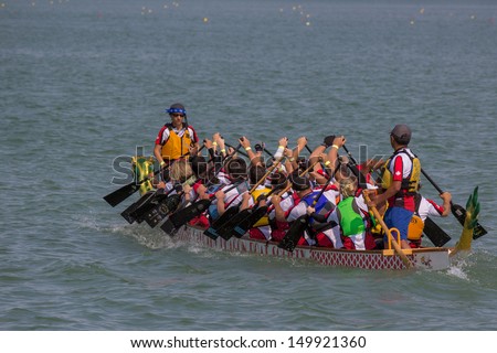 CALGARY, CANADA - AUGUST 11: A Dragon Boat team works together in the annual Calgary Dragon Boat Race & Festival on 11 August 2013 at North Glenmore Park.