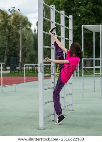 Similar – Image, Stock Photo Focused sportswoman hanging on bar while working out in gym