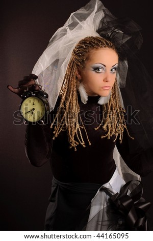 Girl with stage makeup in theatrical costume with clock in her hand