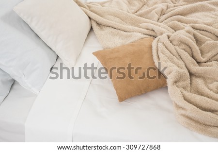 White and beige bedding, pillows and crumpled sheets, white linen cloth, abstract background.