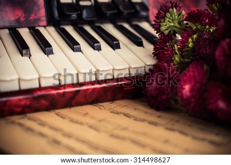 Accordion keys, old notes and a bouquet of flowers, a nostalgic music vintage arrangement