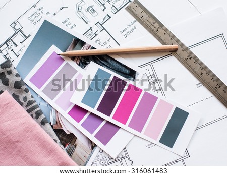 Interior designer\'s working table, an architectural plan of the house, a color palette, furniture and fabric samples in grey and pink color. Drawings and plans for house decoration.
