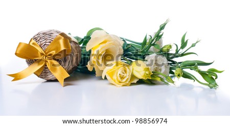 Wicker box with yellow ribbon and a bouquet of eustomas on a white background
