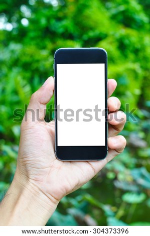 Smartphone in hold hand on green background with copy space