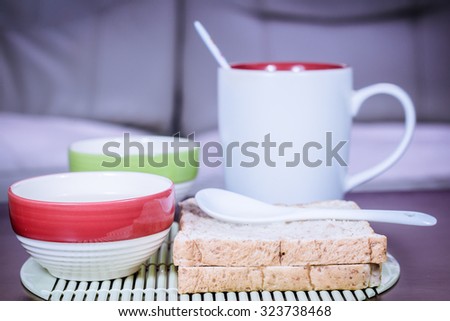 Blur background of bread and cup coffee on the table, Bread and a cup of coffee on a table, The mood vintage background.
