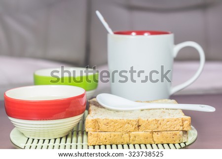 Blur background of bread and cup coffee on the table, Bread and a cup of coffee on a table, The mood vintage background.