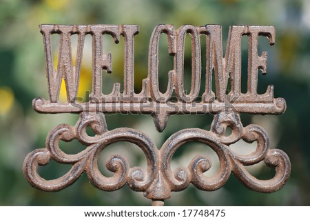 Horizontal image of an iron sign spelling out the word Welcome.