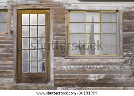 Architectural details of old paned windows and paned door in abandoned, derelict house in Eastern Oregon.