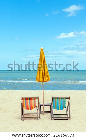 Two beach chairs with sun umbrella on beautiful beach. Concept for rest, relaxation, holiday, spa, resort.