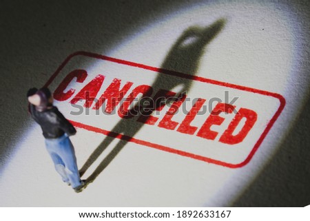 Man stands on cancelled stamp with dark shadow. Person is labelled or stereotyped. Cancel culture concept with noise and grain. Foto stock © 