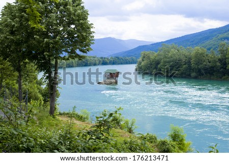 Clear river  (Drina in Serbia) with a little house on a rock in mountains landscape